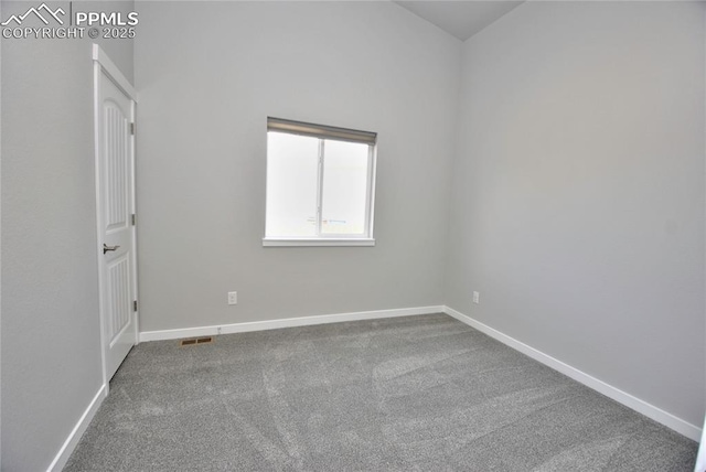 empty room with carpet flooring, visible vents, and baseboards