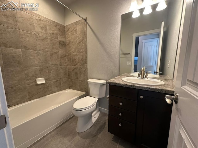 bathroom with vanity, a textured wall, tile patterned floors, toilet, and bathtub / shower combination