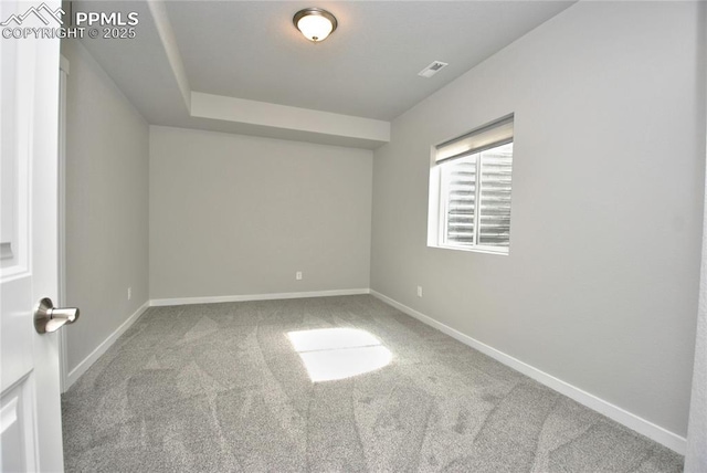 spare room with carpet, visible vents, and baseboards