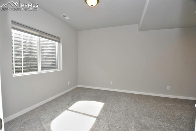 carpeted spare room featuring visible vents and baseboards