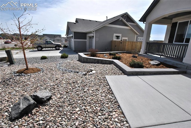 view of home's exterior featuring fence, a garage, and concrete driveway