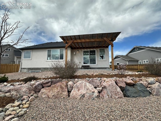 view of front of house featuring a pergola, stucco siding, and fence