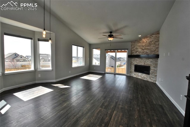 unfurnished living room featuring a stone fireplace, ceiling fan, hardwood / wood-style floors, and vaulted ceiling