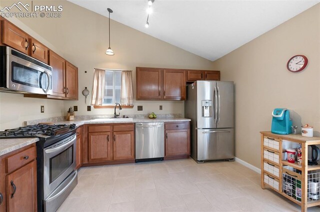 3828 Breaking Dawn St, Colorado Springs, CO 80925 - kitchen with brown cabinetry, vaulted ceiling, appliances with stainless steel finishes, light countertops, and a sink
