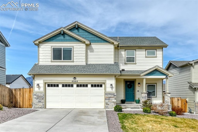 craftsman house featuring a shingled roof, a garage, fence, and stone siding