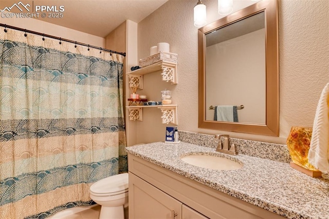 bathroom featuring toilet, a shower with shower curtain, vanity, and a textured wall