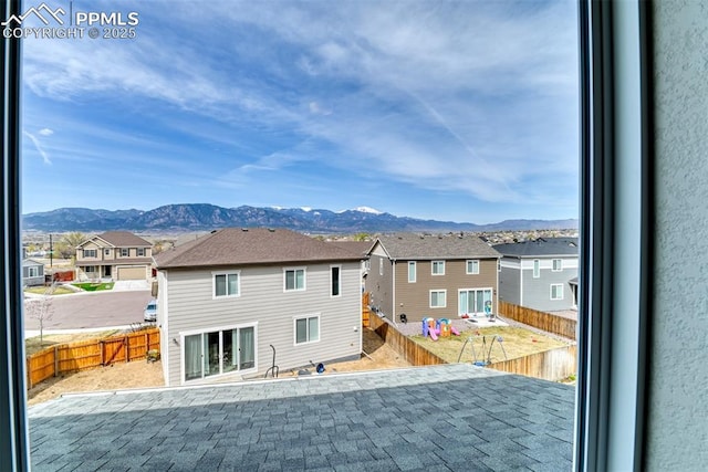 rear view of property with a mountain view, a fenced backyard, and a residential view