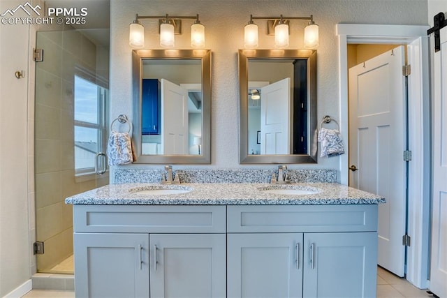 bathroom with a sink, tile patterned floors, a shower stall, and double vanity