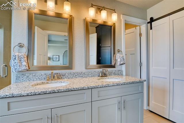 full bath with a sink, double vanity, tile patterned flooring, and a shower with door