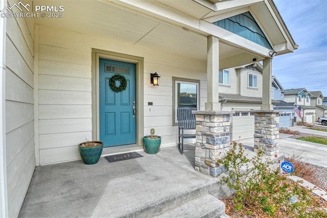 view of exterior entry featuring a porch and an attached garage