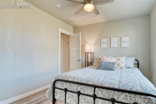 bedroom featuring light wood-style floors, baseboards, and a ceiling fan