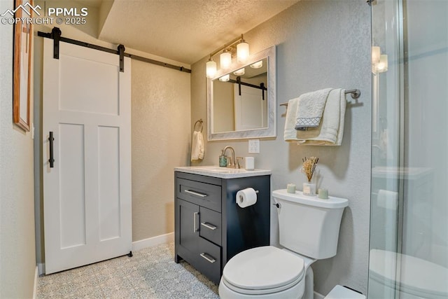 bathroom with a textured wall, vanity, and toilet