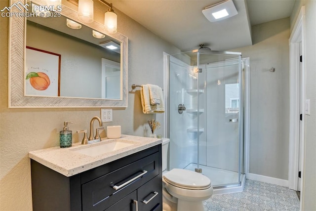 bathroom with a shower stall, vanity, and toilet
