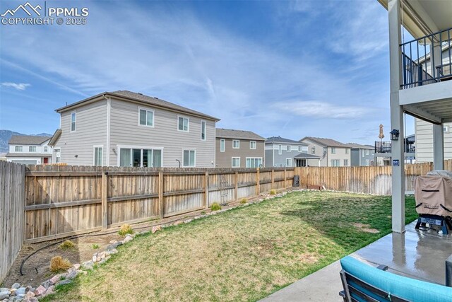view of yard with a residential view, a fenced backyard, and a patio area
