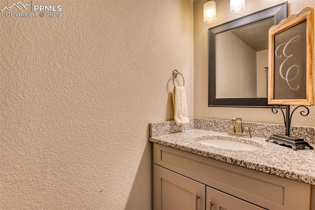 bathroom featuring a textured wall and vanity