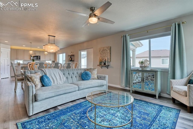 living area featuring ceiling fan, wood finished floors, and a textured ceiling