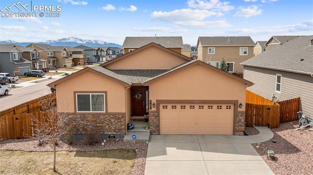 7814 Dry Willow Way, Colorado Springs, CO 80908 - view of front of house featuring stucco siding, stone siding, fence, concrete driveway, and a residential view