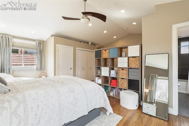 bedroom featuring vaulted ceiling, recessed lighting, a ceiling fan, wood finished floors, and multiple closets