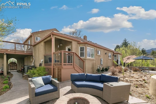 view of patio featuring a wooden deck, an outdoor living space with a fire pit, and central AC unit
