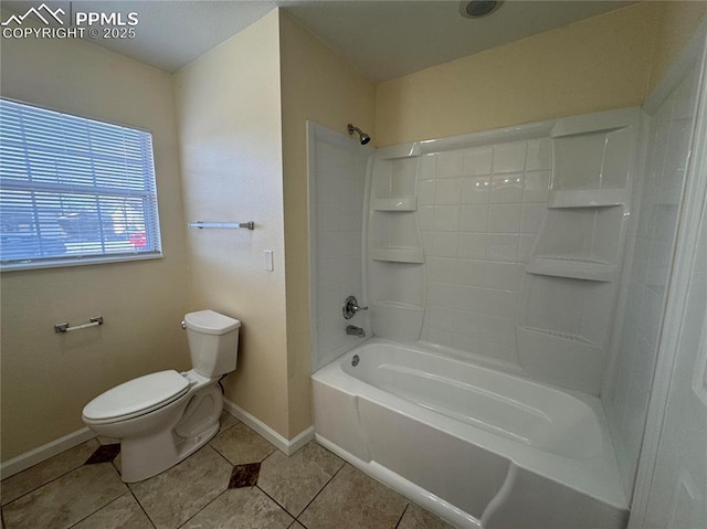 bathroom with bathing tub / shower combination, tile patterned flooring, baseboards, and toilet