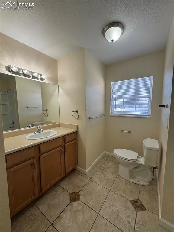 bathroom with baseboards, toilet, a textured ceiling, vanity, and tile patterned floors