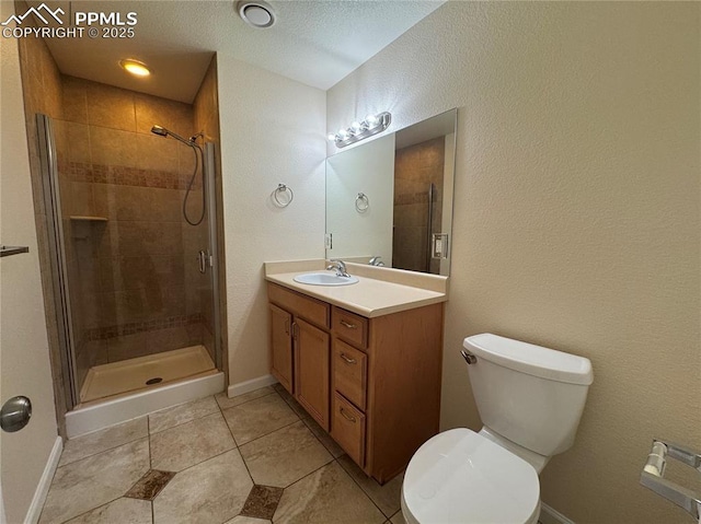bathroom featuring a shower stall, vanity, tile patterned flooring, toilet, and baseboards