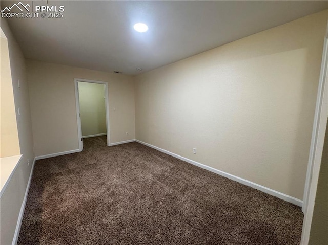 carpeted empty room featuring baseboards