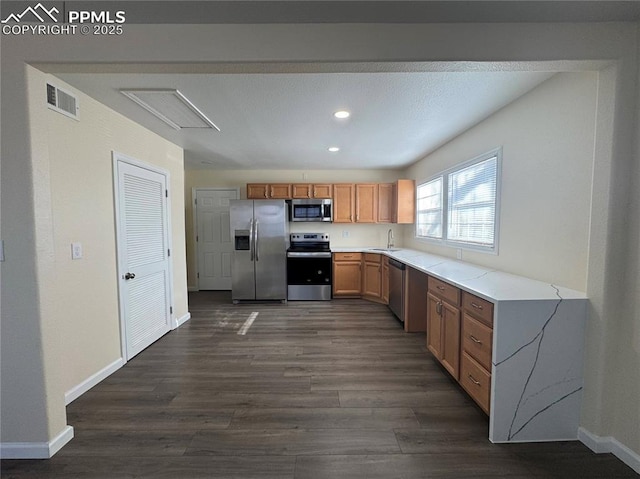 kitchen featuring visible vents, dark wood-style flooring, light countertops, stainless steel appliances, and baseboards