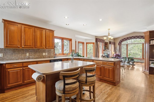 19595 E Top O The Moor Dr, Monument, CO 80132 - kitchen featuring light wood-style floors, a peninsula, a sink, and a notable chandelier