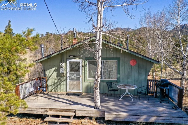 back of property featuring a chimney and a wooden deck