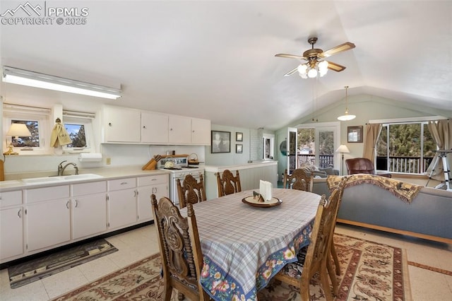dining area featuring lofted ceiling, a ceiling fan, and a healthy amount of sunlight