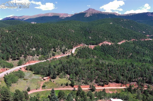 aerial view featuring a wooded view and a mountain view