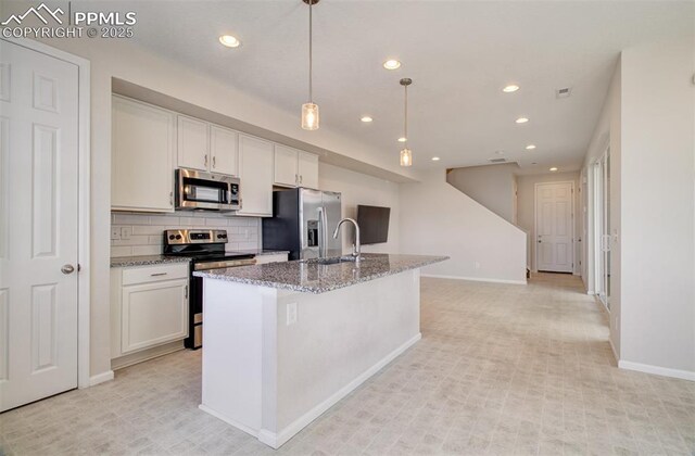 5033 Baseline Vw, Colorado Springs, CO 80920 - kitchen featuring appliances with stainless steel finishes, recessed lighting, baseboards, a kitchen island with sink, and stone countertops