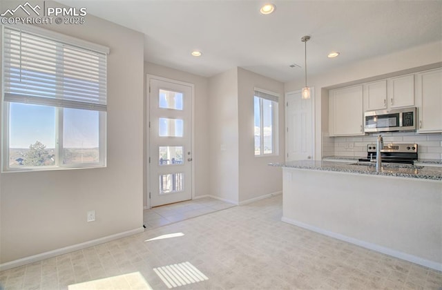 5033 Baseline Vw, Colorado Springs, CO 80920 - kitchen with stainless steel appliances, baseboards, light stone countertops, recessed lighting, and decorative backsplash