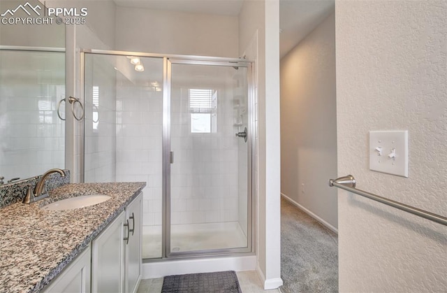 5033 Baseline Vw, Colorado Springs, CO 80920 - full bath featuring a shower stall, vanity, a textured wall, and baseboards