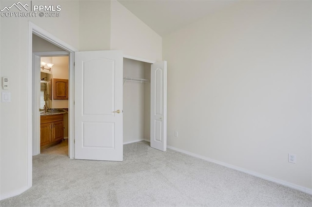 5584 Sonnet Hts, Colorado Springs, CO 80918 - unfurnished bedroom with a closet, baseboards, vaulted ceiling, and light carpet