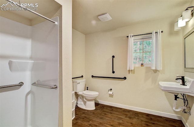 full bathroom with baseboards, walk in shower, wood finished floors, and toilet