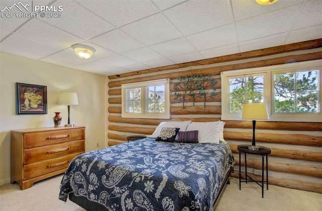 bedroom with rustic walls, carpet flooring, and a drop ceiling