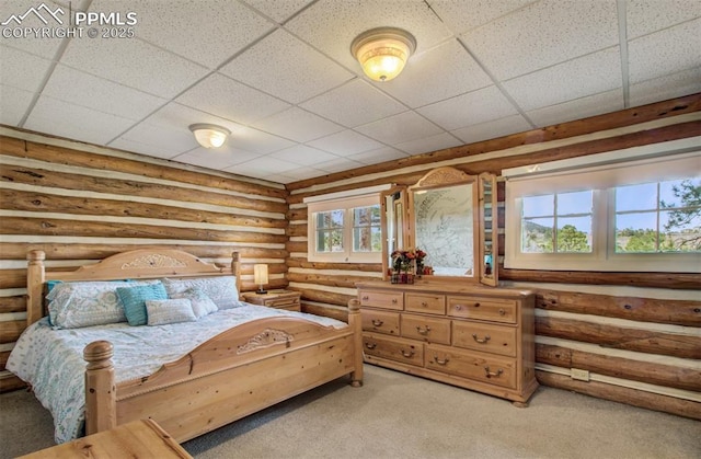 bedroom with light colored carpet, rustic walls, and a paneled ceiling