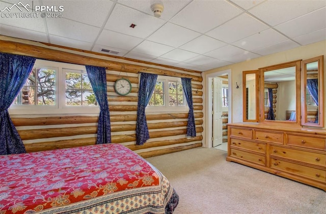 bedroom with rustic walls, a paneled ceiling, visible vents, and carpet flooring