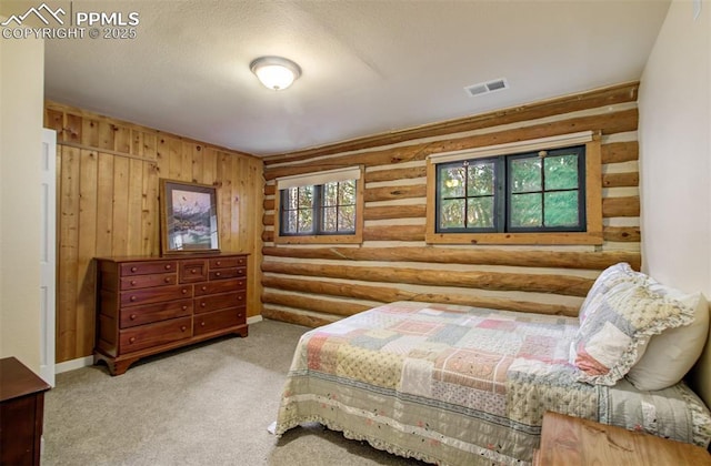carpeted bedroom featuring log walls and visible vents