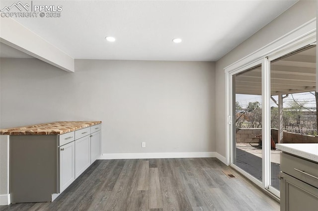 unfurnished dining area featuring visible vents, baseboards, dark wood-style floors, and recessed lighting