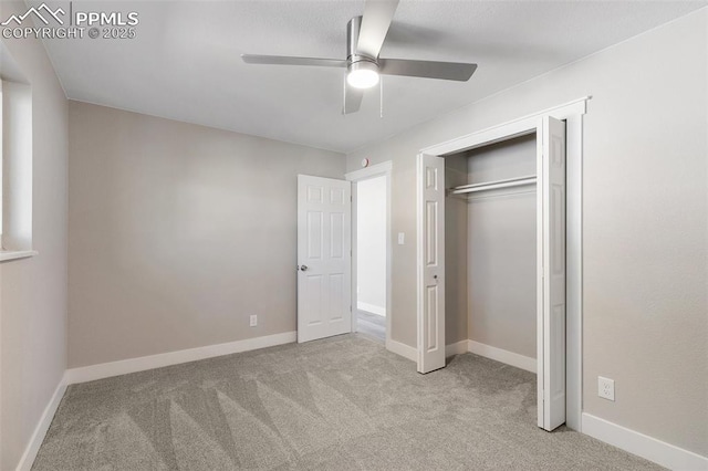 unfurnished bedroom featuring carpet, a closet, a ceiling fan, and baseboards