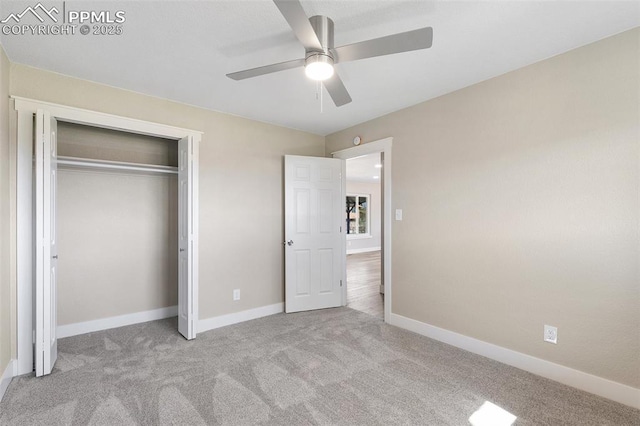 unfurnished bedroom featuring carpet, a closet, baseboards, and ceiling fan
