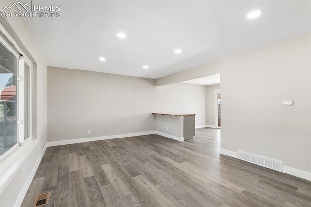 unfurnished room featuring wood finished floors, visible vents, and a wealth of natural light