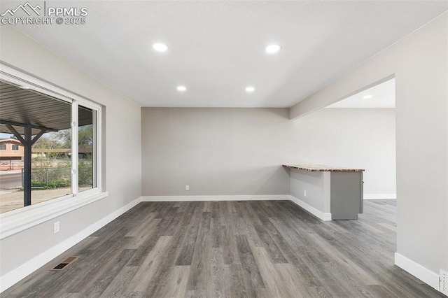 spare room with baseboards, visible vents, recessed lighting, and dark wood-style floors