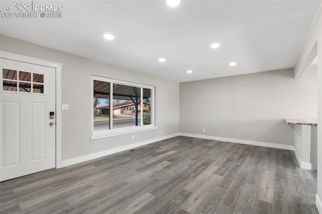 entryway with baseboards, wood finished floors, recessed lighting, and a textured ceiling