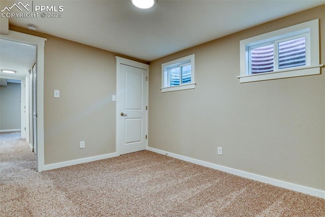 carpeted spare room featuring baseboards
