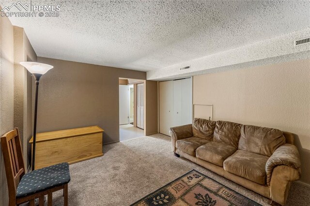 1951 Giltshire Dr, Colorado Springs, CO 80905 - carpeted living room featuring a textured ceiling, a textured wall, and visible vents