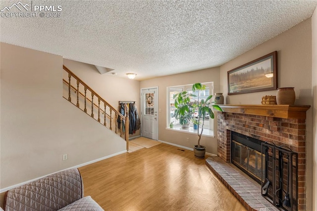 1951 Giltshire Dr, Colorado Springs, CO 80905 - living area with a textured ceiling, stairway, wood finished floors, a brick fireplace, and baseboards